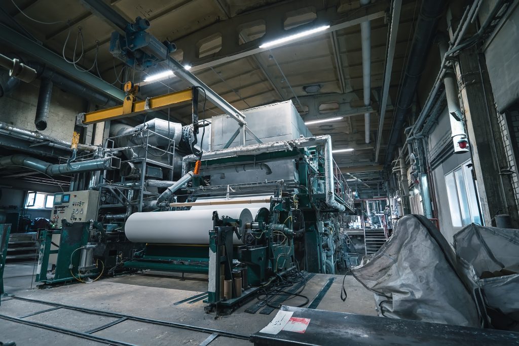 Production machine with rolls of new paper in waste paper recycling factory
